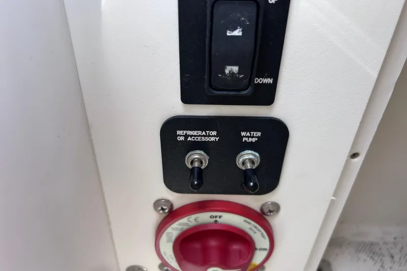 Slide: The Image of Control panel of a 2015 Cobalt 26SD boat with switches for accessories and water pump. - 31
