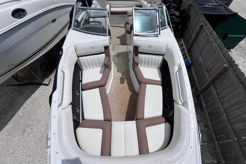 Slide: The Image of 2015 Cobalt 26SD boat interior with white and brown seating, docked beside another vessel. - 33