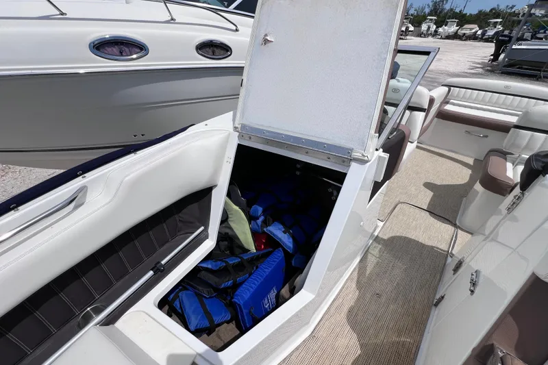 Slide: The Image of 2015 Cobalt 26SD boat interior with open storage compartment and life jackets. - 36