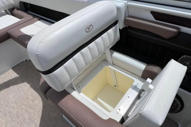 Slide: The Image of 2015 Cobalt 26SD boat seat with built-in storage compartment, featuring white and brown upholstery. - 38
