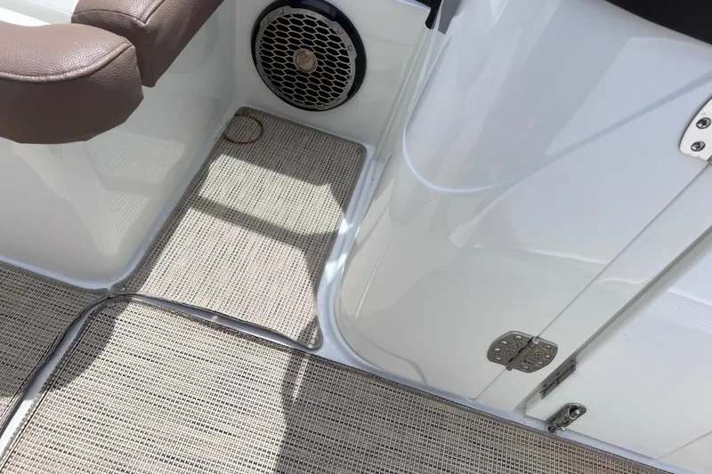 Slide: The Image of 2015 Cobalt 26SD boat interior with speaker, brown seat, and textured flooring. - 40