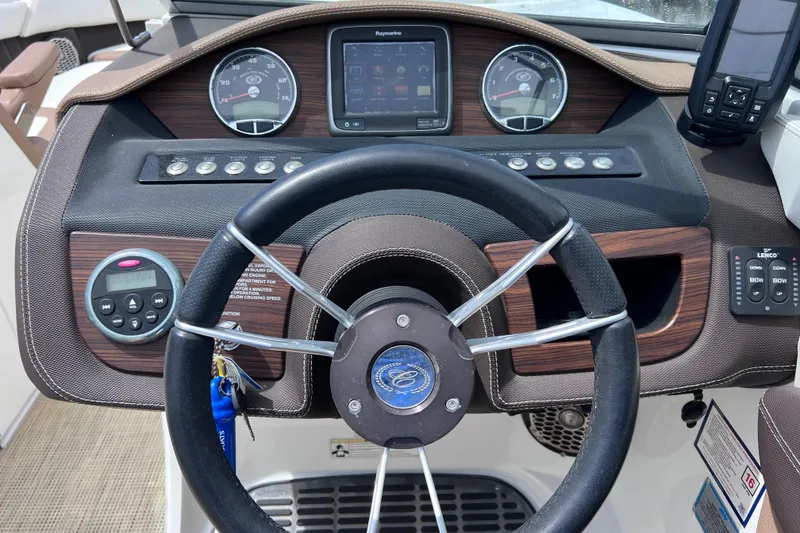 Slide: The Image of Steering wheel and dashboard of a 2015 Cobalt 26SD boat with gauges and controls. - 43