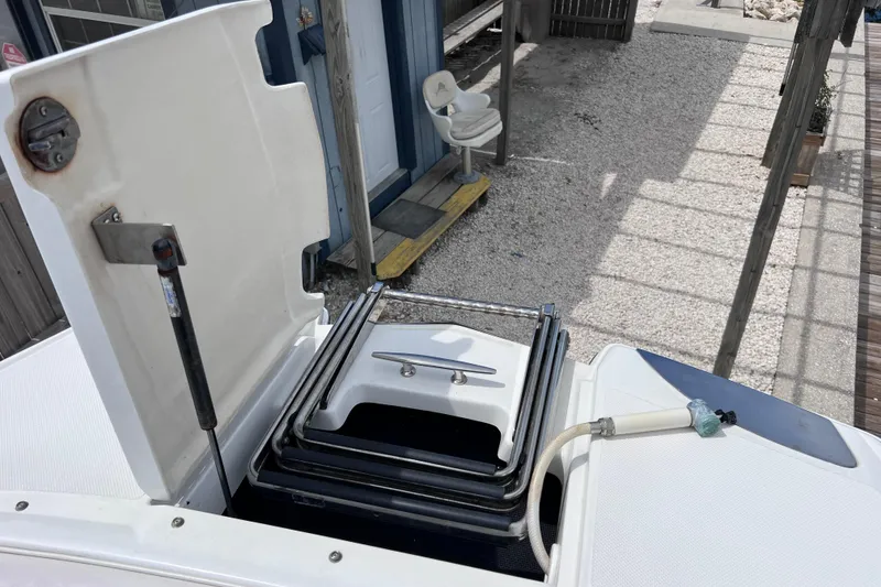 Slide: The Image of 2015 Cobalt 26SD boat with open storage compartment and ladder, dockside view. - 58