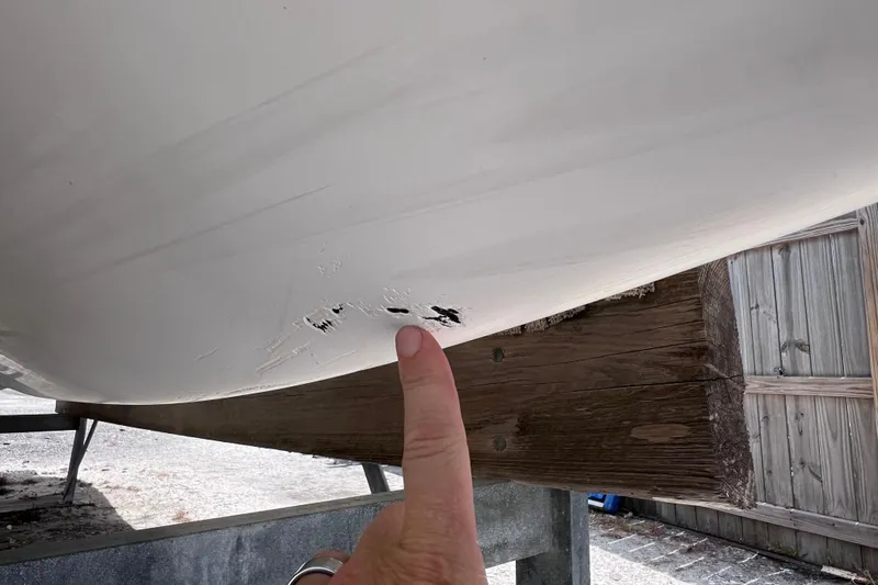 Slide: The Image of 2015 Cobalt 26SD boat hull with visible scratches and damage. - 6