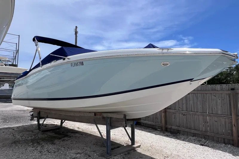 Slide: The Image of 2015 Cobalt 26SD boat on stand, blue cover, clear sky background. - 7