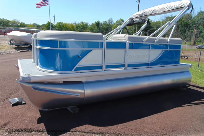 The Image of 2026 Godfrey eX1680 CX pontoon boat with blue and white design, parked outdoors. - 1