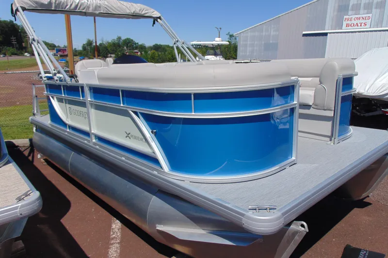Slide: The Image of 2026 Godfrey eX1680 CX pontoon boat with blue and white exterior, docked outdoors. - 3