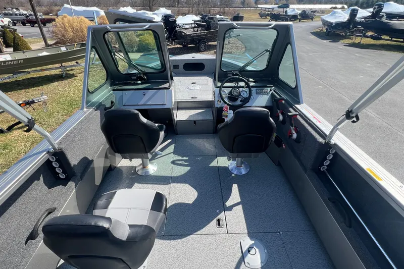 Slide: The Image of 2025 Crestliner 1850 Commander boat interior with dual seats and steering console. - 13