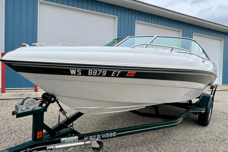 Slide: The Image of 2000 Four Winns 190 Horizon SS boat on trailer, parked near blue building. - 10