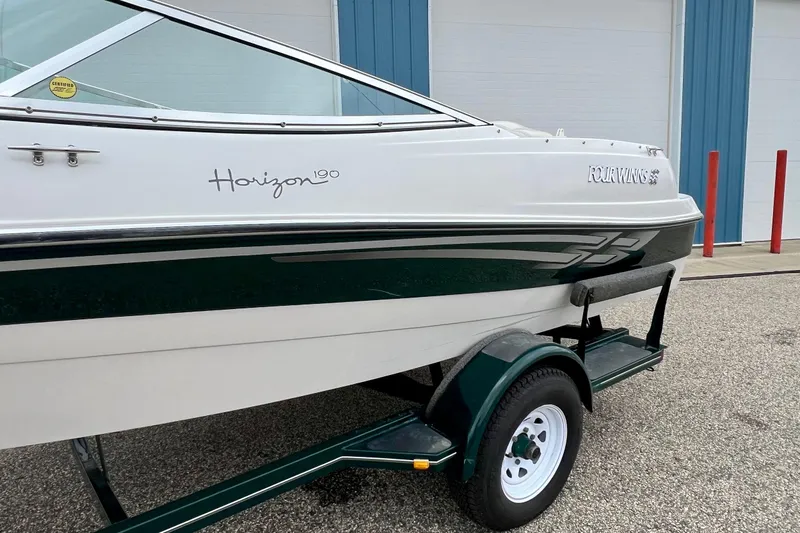 Slide: The Image of 2000 Four Winns 190 Horizon SS boat on trailer, white and green exterior. - 11