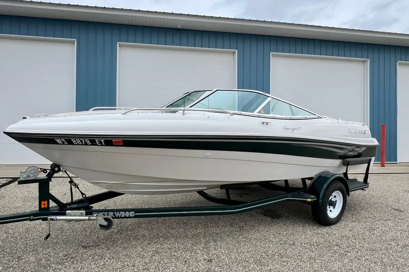 Slide: The Image of 2000 Four Winns 190 Horizon SS boat on trailer, parked outside blue building. - 9