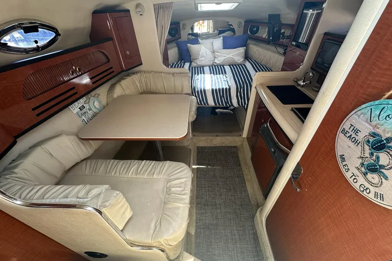 Slide: The Image of Interior of 2004 Sea Ray 280 Sundancer with cozy seating and compact kitchen area. - 10