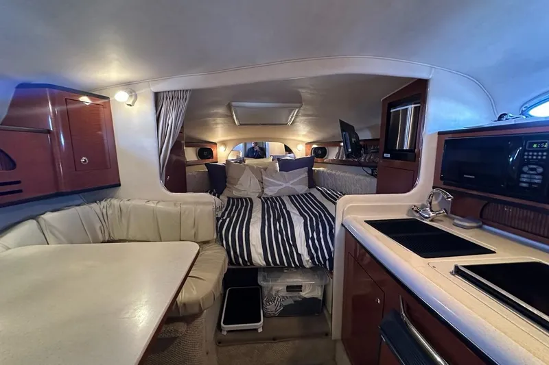 Slide: The Image of Interior of 2004 Sea Ray 280 Sundancer boat with kitchen, seating, and sleeping area. - 11