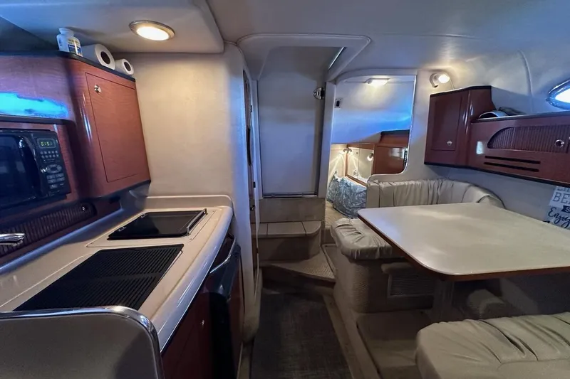 Slide: The Image of Interior of 2004 Sea Ray 280 Sundancer with kitchenette and dining area. - 12