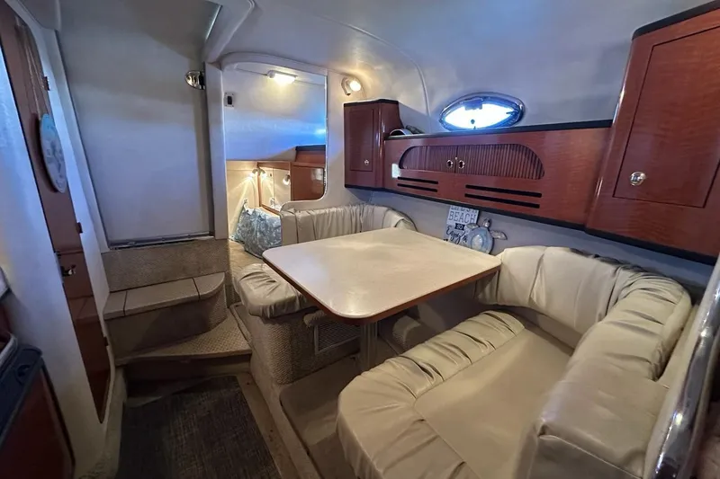 Slide: The Image of Interior of 2004 Sea Ray 280 Sundancer with cozy seating and wooden cabinetry. - 17