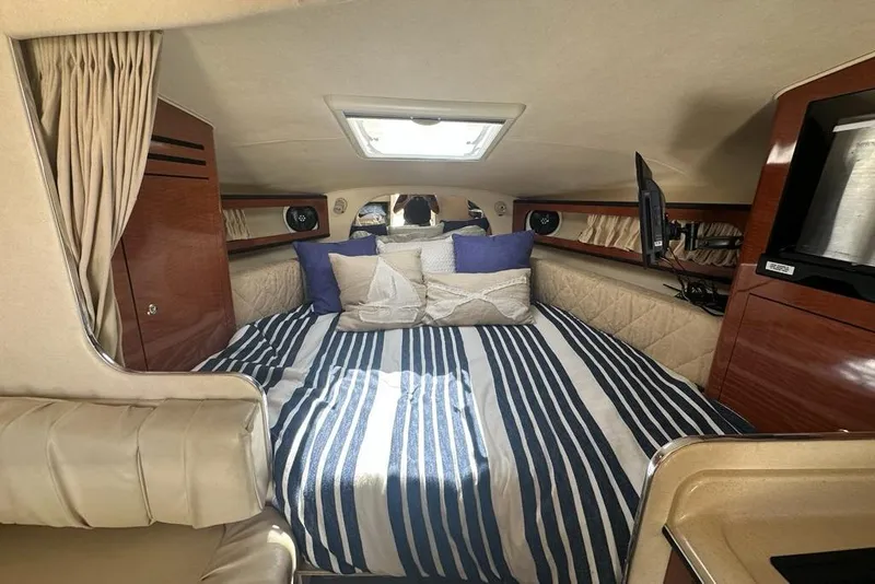 Slide: The Image of Luxurious cabin interior of 2004 Sea Ray 280 Sundancer with striped bedding and wood accents. - 19
