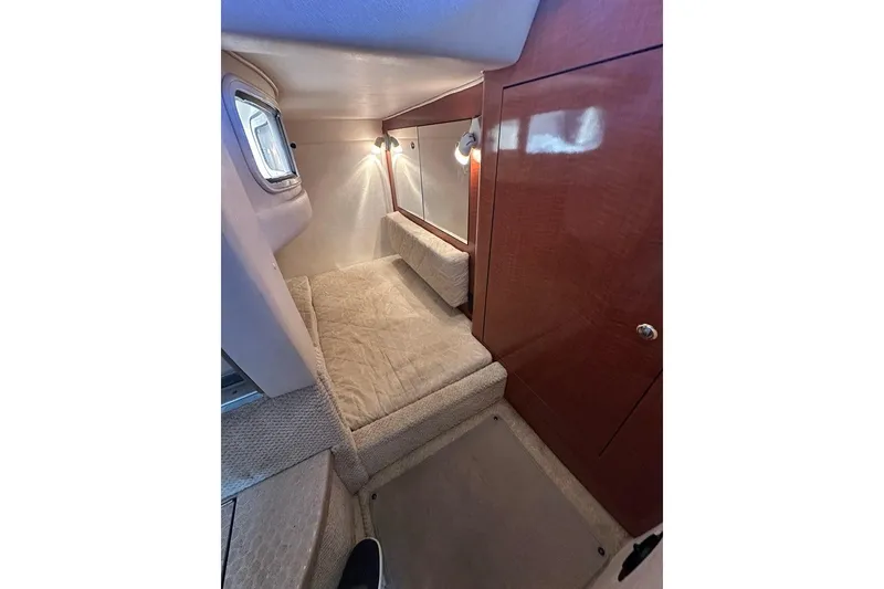 Slide: The Image of Interior cabin of 2004 Sea Ray 280 Sundancer with cozy bed and wooden cabinetry. - 20
