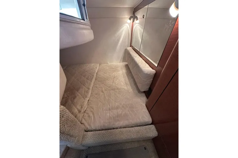 Slide: The Image of 2004 Sea Ray 280 Sundancer cabin interior with cozy bed and soft lighting. - 21