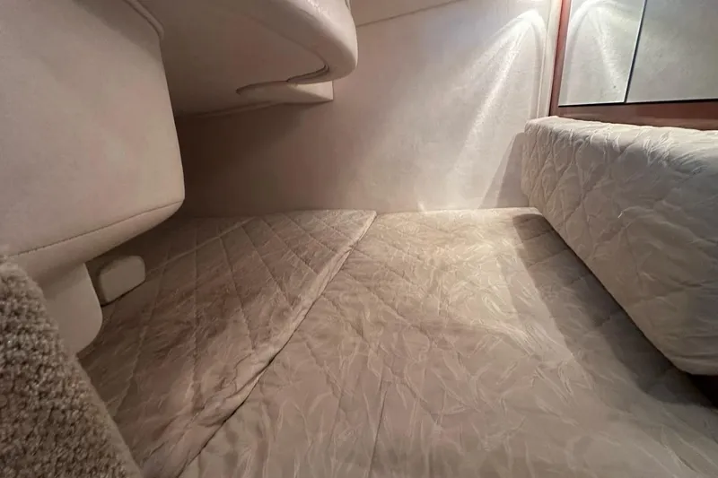 Slide: The Image of Interior cabin of 2004 Sea Ray 280 Sundancer with cozy bedding and soft lighting. - 22