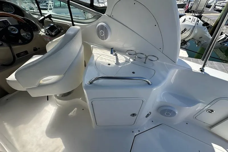 Slide: The Image of 2004 Sea Ray 280 Sundancer cockpit with helm, seating, and sink area. - 6