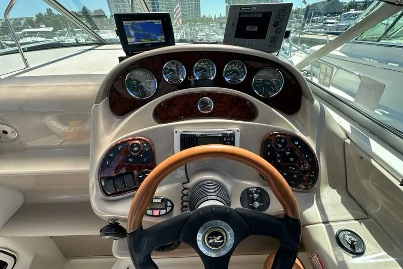Slide: The Image of 2004 Sea Ray 280 Sundancer helm with gauges, GPS, and wood-accented steering wheel. - 7