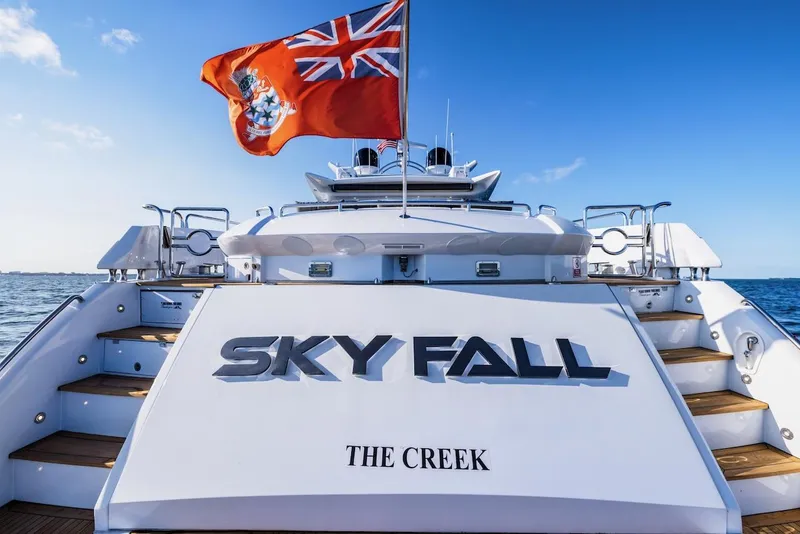 Slide: The Image of 2008 Sunseeker Predator 108 yacht with flag, named "Sky Fall," docked at sea. - 3