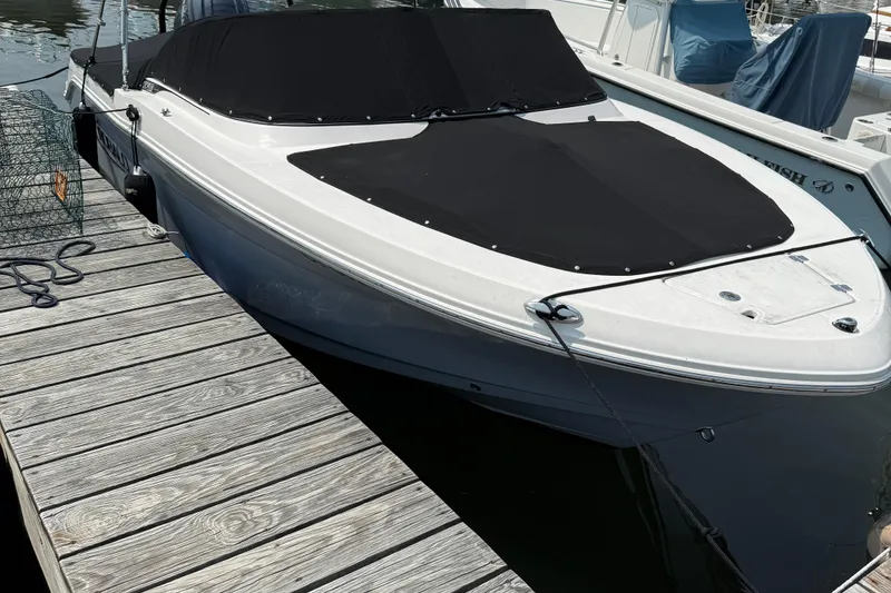 Slide: The Image of 2023 Robalo R207 Dual Console boat docked with black cover. - 11