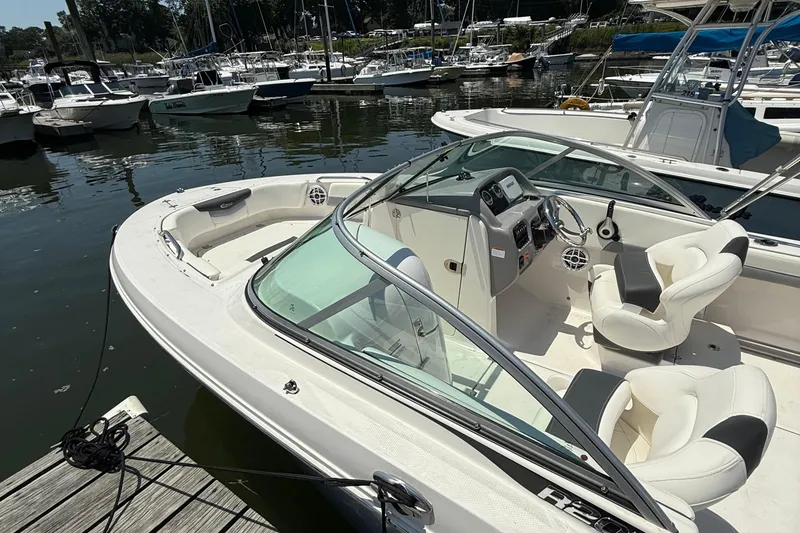 Slide: The Image of 2023 Robalo R207 Dual Console boat docked at marina, featuring sleek design and comfortable seating. - 12