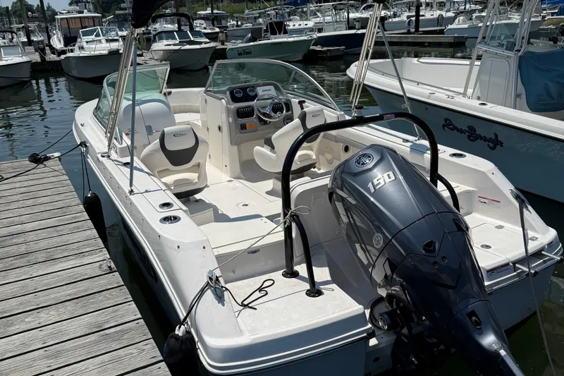 Slide: The Image of 2023 Robalo R207 Dual Console boat docked, featuring a 150 horsepower engine. - 7