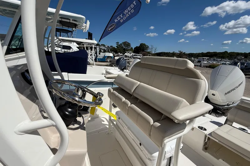 Slide: The Image of 2026 Boston Whaler 250 Dauntless boat interior with steering wheel and seating, under clear blue sky. - 11