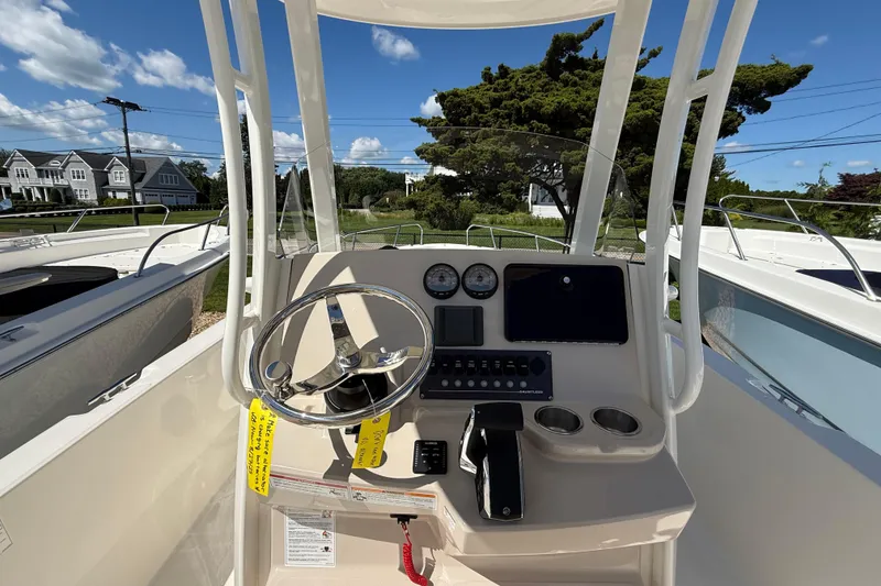 Slide: The Image of 2026 Boston Whaler 250 Dauntless boat console with steering wheel and controls. - 13