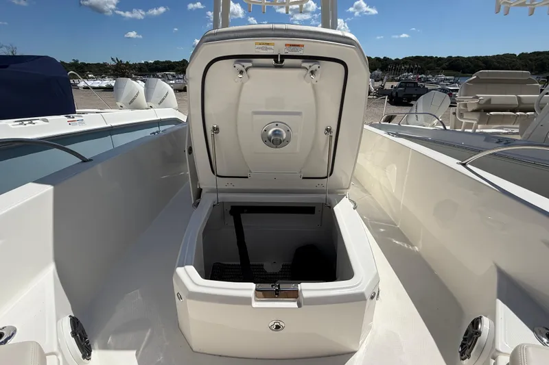 Slide: The Image of 2026 Boston Whaler 250 Dauntless boat storage compartment open under clear sky. - 16