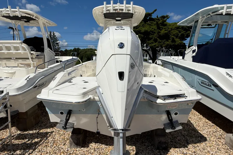 Slide: The Image of 2026 Boston Whaler 250 Dauntless boat displayed outdoors on gravel. - 4