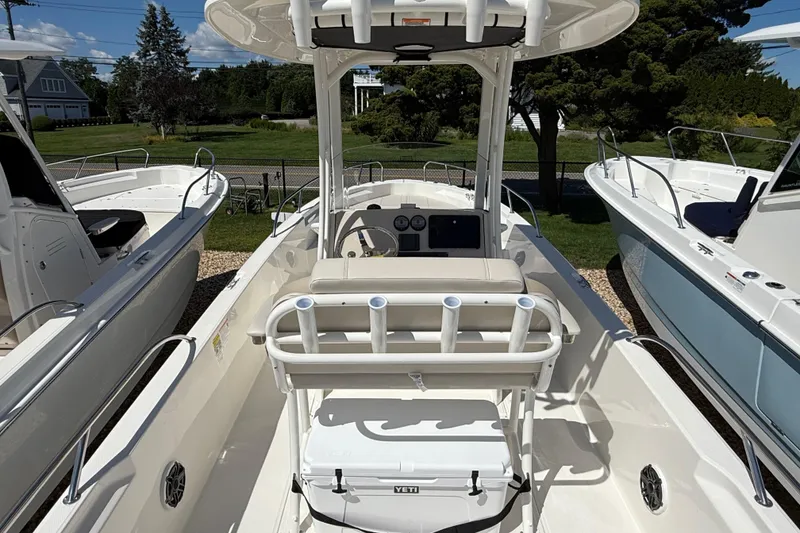 Slide: The Image of 2026 Boston Whaler 250 Dauntless boat interior with helm and seating, docked outdoors. - 9