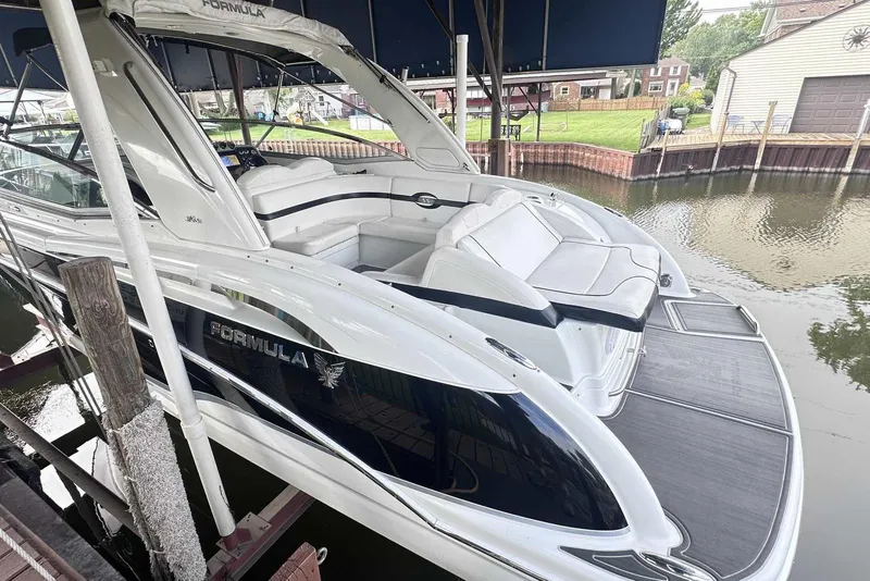 Slide: The Image of 2007 Formula 310 Sun Sport boat docked, featuring sleek white design and spacious seating. - 4