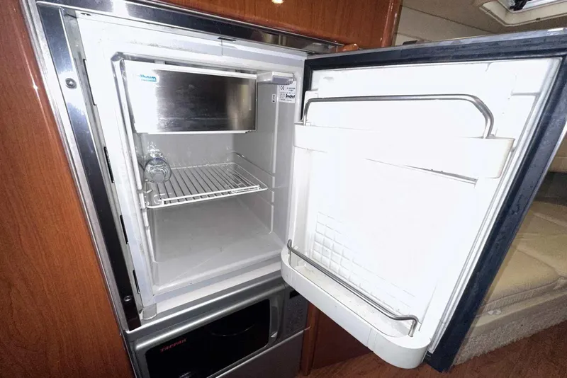 Slide: The Image of Open refrigerator inside 2007 Formula 310 Sun Sport boat, showcasing interior shelving. - 45
