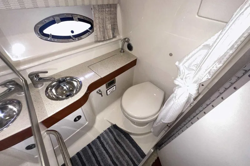 Slide: The Image of 2007 Formula 310 Sun Sport bathroom with sink, toilet, and porthole window. - 49