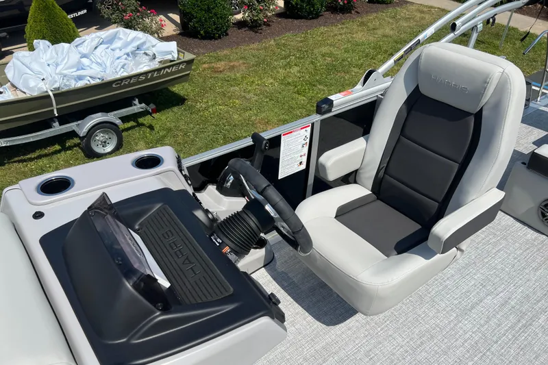 Slide: The Image of 2025 Harris Cruiser 230 boat interior with captain's chair and steering console. - 15