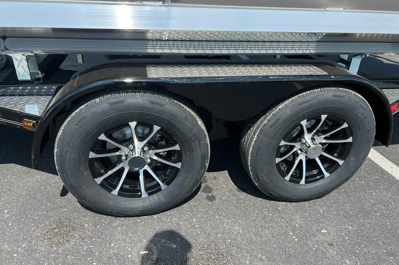 Slide: The Image of 2025 Harris Cruiser 230 trailer wheels, black rims, parked on asphalt. - 5