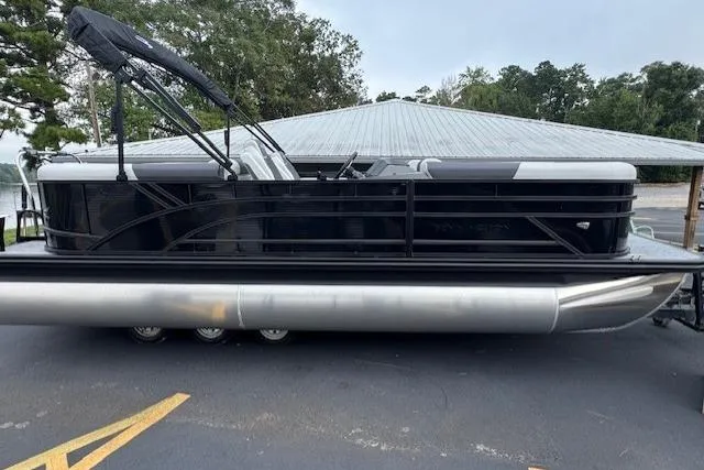 Slide: The Image of 2026 Bennington 22 SSR pontoon boat parked on pavement near a metal-roofed building. - 2
