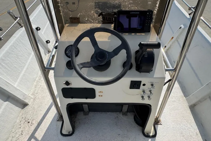 Slide: The Image of 1998 Coastal Skiff 19 boat console with steering wheel and navigation equipment. - 10