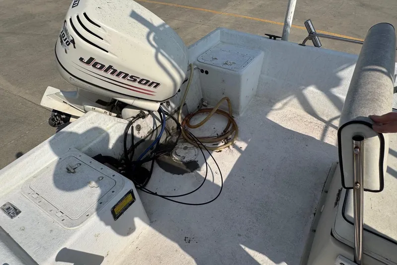 Slide: The Image of 1998 Coastal Skiff 19 boat interior with Johnson outboard motor, showing seating and deck details. - 14