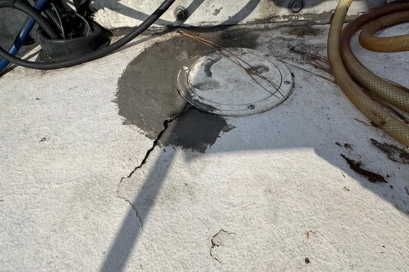 Slide: The Image of Cracked deck of 1998 Coastal Skiff 19 with visible repair and hoses. - 18