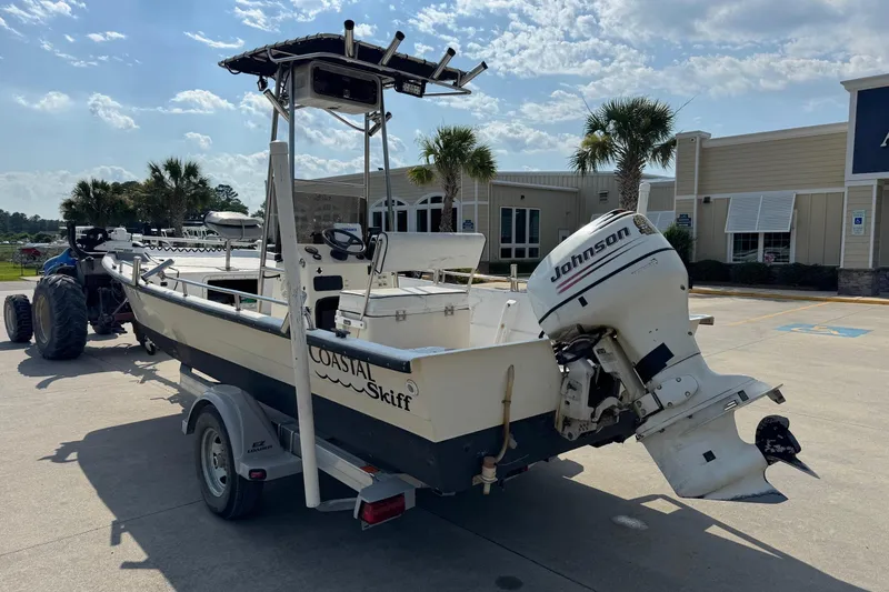 Slide: The Image of 1998 Coastal Skiff 19 boat with Johnson outboard motor on trailer, sunny day. - 4