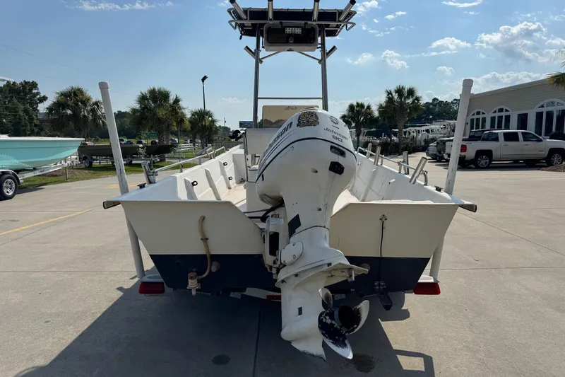 Slide: The Image of 1998 Coastal Skiff 19 with Johnson outboard motor, parked outdoors on a sunny day. - 5