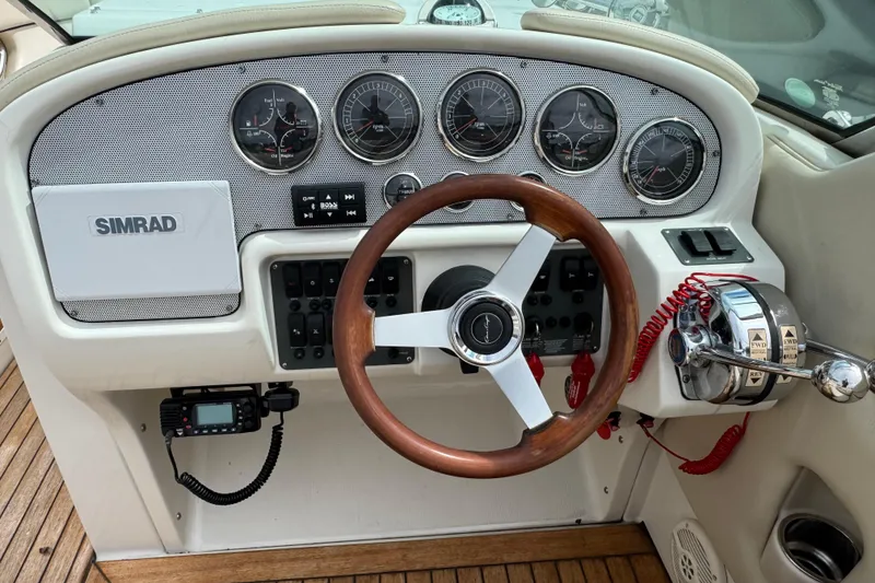 Slide: The Image of 2007 Chris-Craft Launch 28 dashboard with wooden steering wheel and Simrad navigation system. - 11