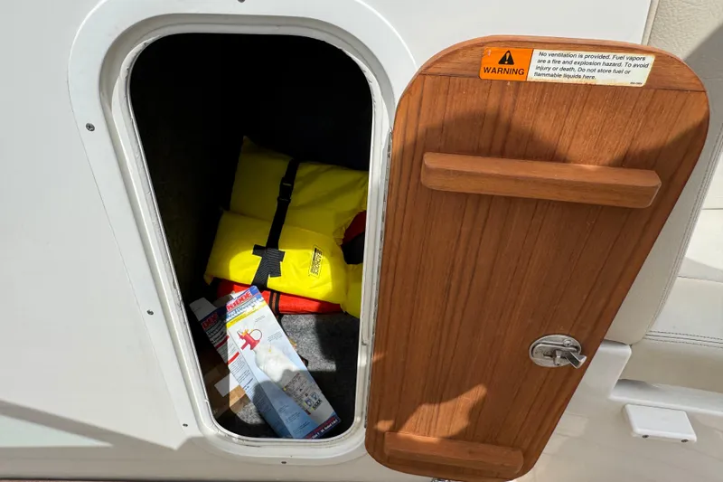 Slide: The Image of Open storage compartment on 2007 Chris-Craft Launch 28 with life jackets and safety equipment. - 14