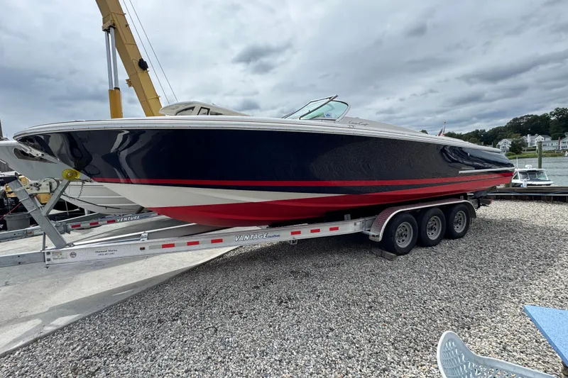Slide: The Image of 2007 Chris-Craft Launch 28 boat on trailer, navy and red design, dockside view. - 2