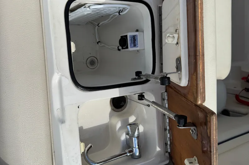 Slide: The Image of 2007 Chris-Craft Launch 28 boat interior storage compartment with faucet and wooden door. - 20