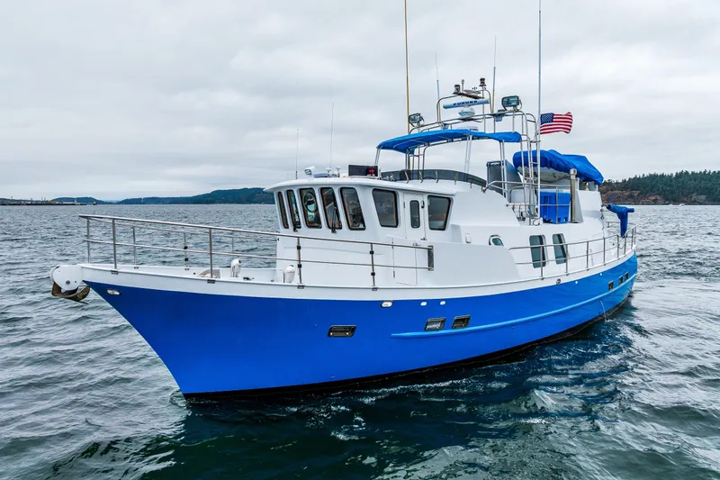 The Image of 1978 Hidden Harbor Custom Trawler, blue and white, cruising on open water. - 0